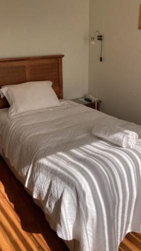 PurénFragaria Hotel Gastrobar的卧室配有白色的床和木制床头板