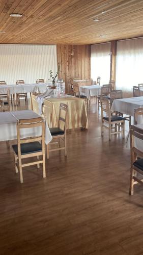 PurénFragaria Hotel Gastrobar的一间设有白色桌椅的用餐室