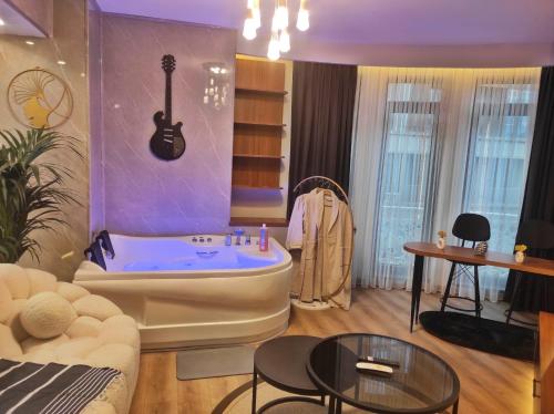 伊斯坦布尔SABIHA GOKCEN HOTEL İSTANBUL HOUSES的客厅设有壁挂吉他和浴缸