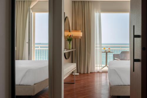 塔兰托Hotel Delfino Taranto的酒店客房设有两张床,享有海景。