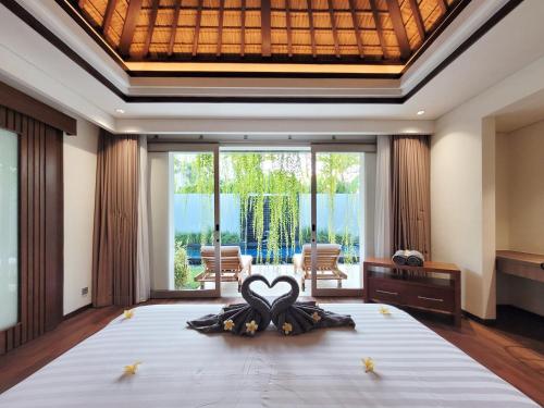 金巴兰Bali - Jimbaran Bay 2 Bedroom Villa的一间卧室设有一张大床和大窗户