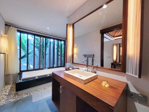 金巴兰Bali - Jimbaran Bay 2 Bedroom Villa的一间带水槽和大镜子的浴室