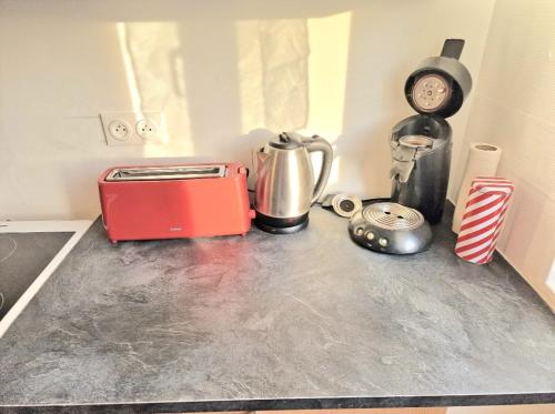 欧里亚克Maison à Aurillac - 3 chambres - Arrivée autonome的厨房台面配有烤面包机和时钟
