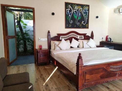 阿贡达Agonda Beach Villa的一间卧室配有一张大型木床和椅子