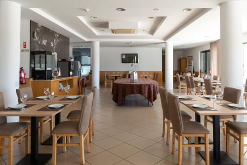 维塞乌杜拉奥酒店的用餐室配有木桌和椅子