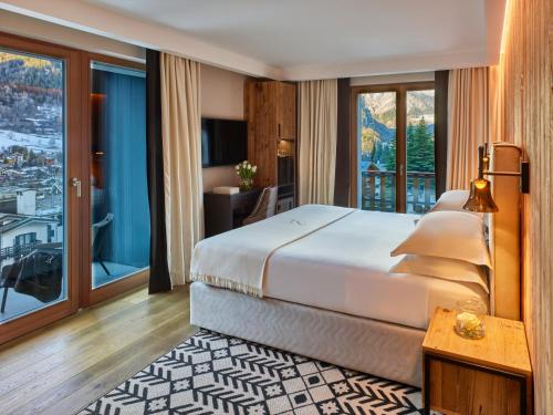 库马约尔Le Massif Hotel & Lodge Courmayeur The Leading Hotels of the World的一间卧室设有一张大床和一个大窗户