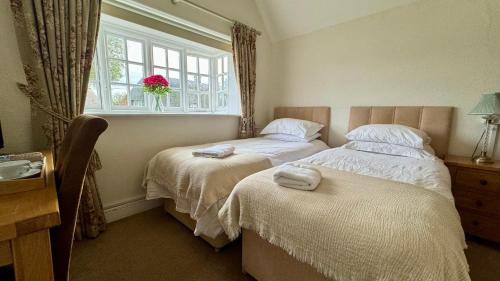 温彻斯特The Cricketers Inn的一间卧室设有两张床和窗户。