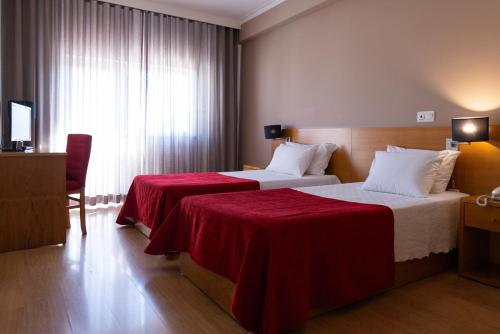 维塞乌杜拉奥酒店的酒店客房,配有两张带红色床单的床