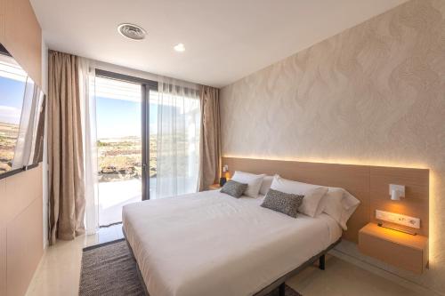阿德耶Villa Andrea, quiet luxury, sunset with sea views的一间卧室设有一张大床和一个大窗户