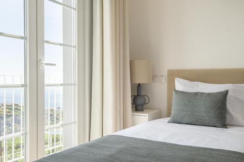 蓬他达维托亚Casas da Luz by Madeira Sun Travel的一间卧室设有一张床和一个大窗户