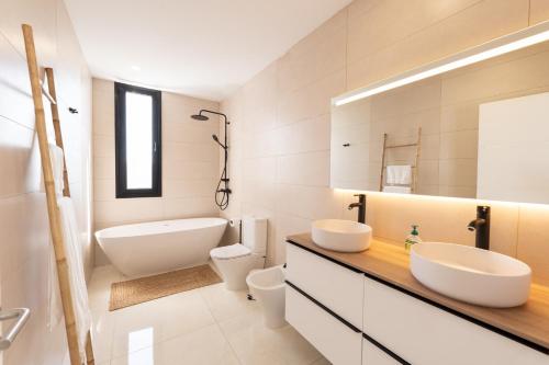 阿德耶Villa Andrea, quiet luxury, sunset with sea views的一间带两个盥洗盆、浴缸和卫生间的浴室