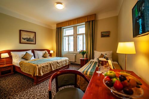 布拉格友迪瓦拉酒店的酒店客房,配有床和一张带水果的桌子