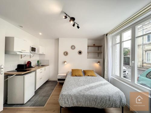 沙泰勒罗Les studios d'Elina的一间卧室配有一张床,厨房配有窗户