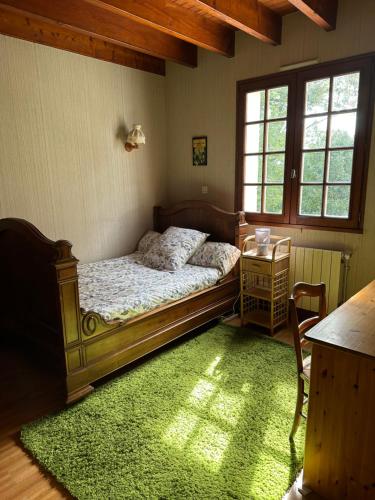 尚尼耶Maison de campagne cosy dans la verdure的一间卧室配有床和绿色地毯