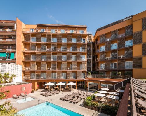 罗列特海岸ALEGRIA Plaza Paris 4*Sup的享有酒店的景致,设有游泳池、椅子和遮阳伞