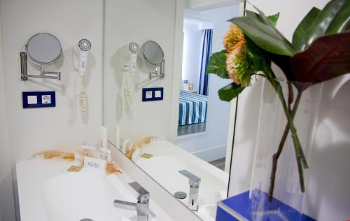 罗列特海岸ALEGRIA Sun Village的浴室设有镜子和花瓶