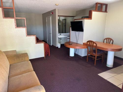 圣安东尼奥Rodeway Inn & Suites South of Fiesta Park的客厅配有沙发和带电视的桌子