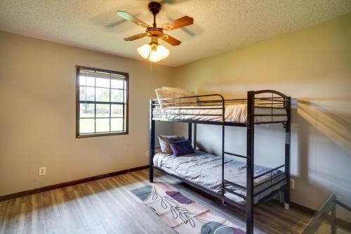 查尔斯湖Charming Lake Charles Home with Patio and Grill的客房设有两张双层床和吊扇。