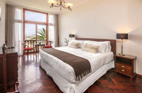 圣萨尔瓦多德朱图斯德拉韦纳酒店的一间卧室配有一张大床和一张桌子及椅子
