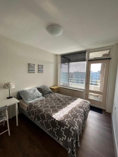 吕伐登Apartment with city skyline的一间卧室配有一张床、一张书桌和一个窗户。