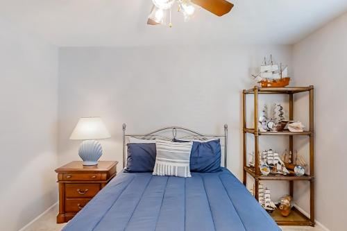 默特尔比奇3rd Avenue Oasis的一间卧室配有一张带灯具和架子的蓝色床。