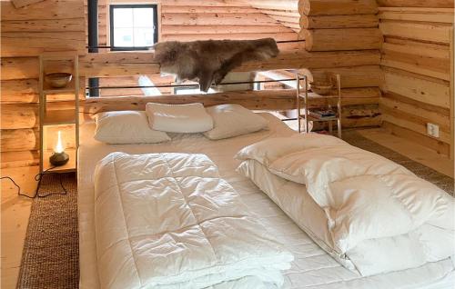 KittelfjällAmazing Home In Kittelfjll With House A Mountain View的小木屋内的一张床位,一只猫跳上小木屋