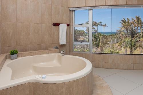 马盖特The Beach Palace Ramsgate的带浴缸的浴室和大窗户