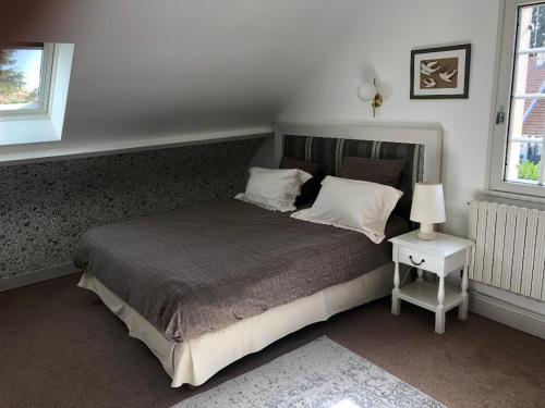 翁赞Le clos fleuri - Chambres d'hôtes的一间卧室配有一张床和一个带灯的床头柜