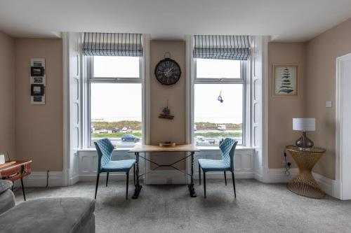 莱瑟姆-圣安妮BEACH VIEW - Amazing Sea Views的客厅配有桌椅和时钟