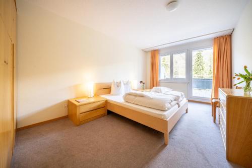武尔佩拉PL 202 Lichtdurchflutete Wohnung mit grossem Balkon Richtung Scuol的一间卧室设有一张床和一个大窗户