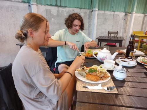 马特勒Seadina Coral Home的坐在餐桌旁吃食物的男人和女人