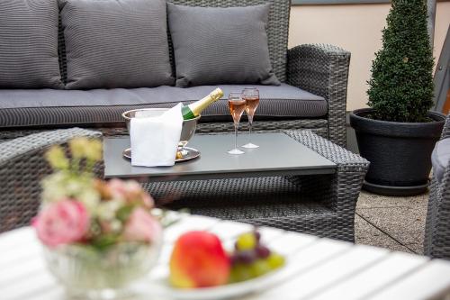 格赖夫斯瓦尔德科隆普林兹酒店的一张桌子,上面放着一瓶香槟和两杯酒