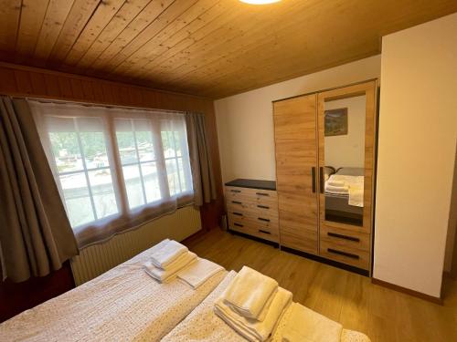 迈林根Pension Balm的一间卧室设有两张床、一个梳妆台和窗户。
