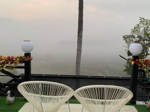 考科Elevated Serenity Lodge in Khao Kho的阳台顶部设有两把白色椅子