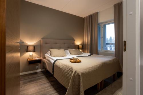 沃卡蒂Vuokatti Booking Suites的一间卧室设有一张大床和一个窗户。