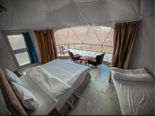 瓦迪拉姆RUM EiLEEN LUXURY CAMP的一间卧室设有两张床和一个美景窗户。