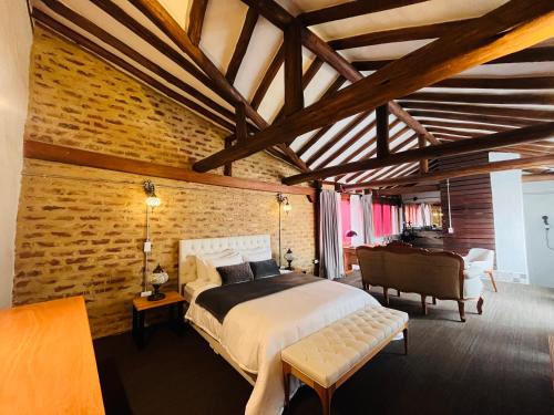 莱瓦镇Hotel Caney Villa de Leyva by MH的一间卧室设有一张床和砖墙