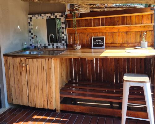 侯斯普瑞特The Dreamcatcher Lodge的厨房配有带水槽和凳子的台面