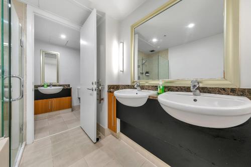 奥克兰Fabulous Corner Apartment w/ Dazzling Harbour View的一间带两个盥洗盆和大镜子的浴室