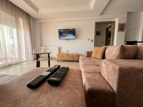 莫纳斯提尔Palm Lake Resort Folla Monastir/Sousse的客厅,沙发上有两个遥控器