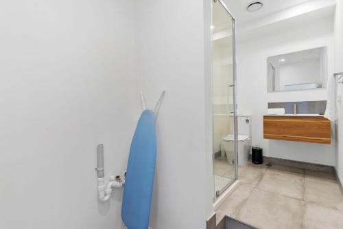 奥克兰Manukau Studio Apartments的浴室设有挂在墙上的蓝色冲浪板