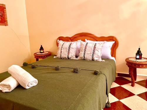 OunaraBelle villa privé的一间卧室配有一张带绿毯和枕头的床。