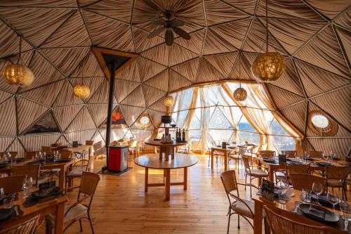 百内三塔巴塔哥尼亚生态露营酒店的蒙古包内带桌椅的用餐室