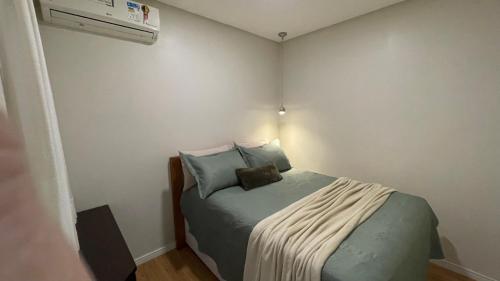 布卢梅瑙Apto climatizado 3 quartos a 3,7km da Vila Germânica的一间带床和加热器的小卧室