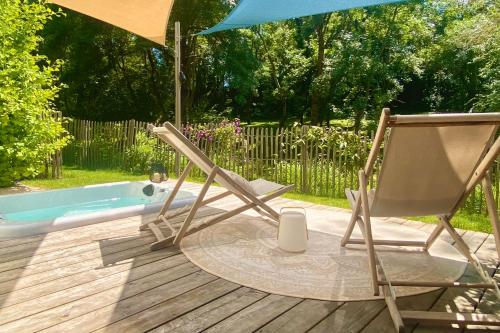 阿尔比Chambres avec Jacuzzi privatif - Kassiopée Bed & Spa的浴缸旁的甲板上摆放着椅子和遮阳伞