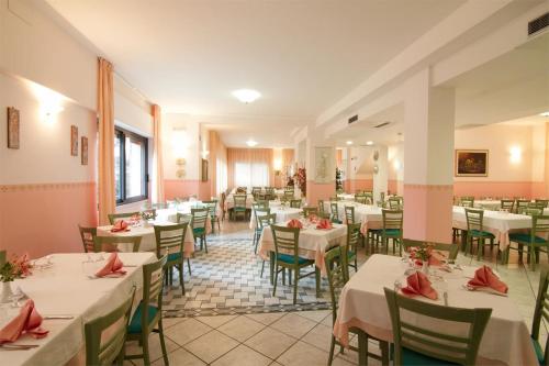 圣乔瓦尼·罗通多Hotel San Francesco的一间设有白色桌椅的用餐室