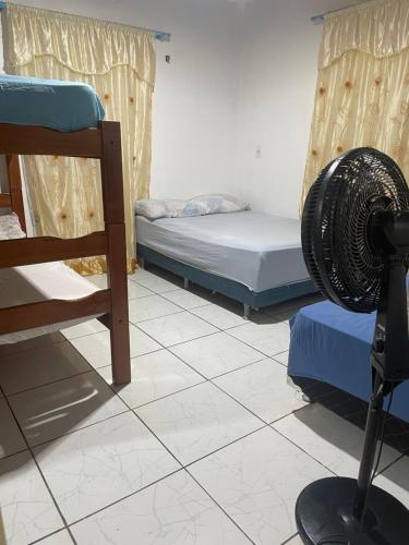 博阿维斯塔Hostel Carol的一间位于地板上的客房,配有两张床和风扇
