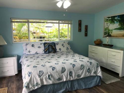 Hawaiian Paradise ParkStunning Ocean Views - Whale House Hawaii的一间卧室设有一张床和一个窗口