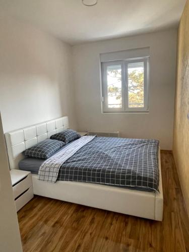 BratunacStan na dan Bratunac的一间卧室设有一张床和一个窗口