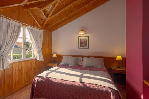 圣马丁德洛斯Sol y Nieve的一间卧室设有一张床和两个窗户。